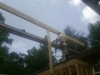 Carpenter setting a ridge beam over a new addition frame — Ice Dam Removal by Roofing Brothers in Toughkenamon