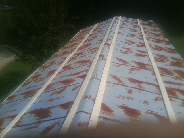Rusted metal roof panels with new wood purlins before replacement — Storm Damage Roof Repair in Toughkenamon by Roofing Brothers