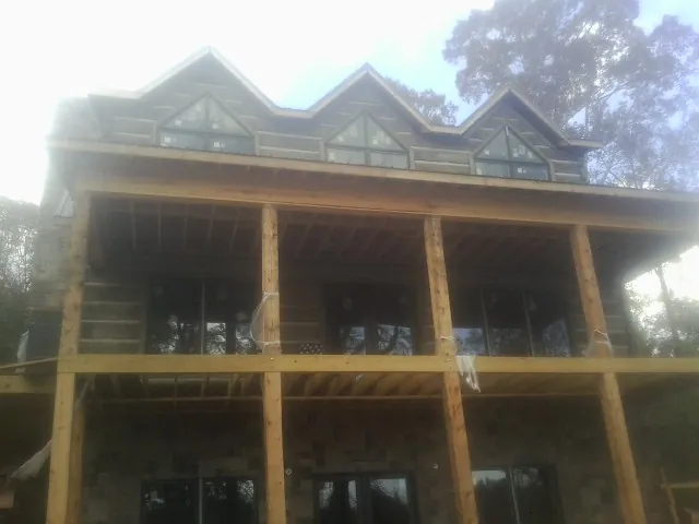 Dormers and porch framing on a large log home under construction — Roof Coating work by our crew in Toughkenamon