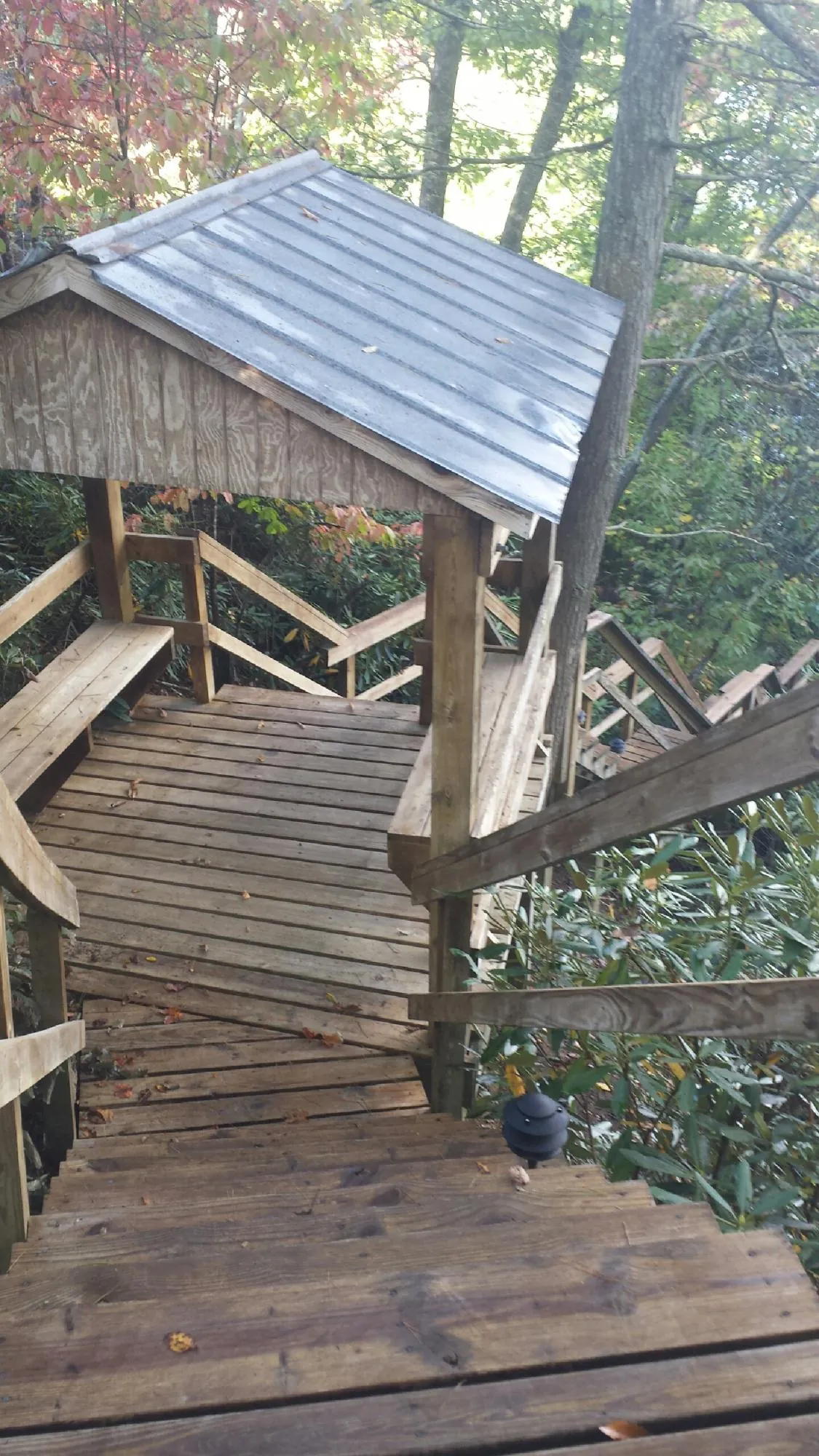 Metal roofed shelter over wooden steps on a wooded walkway — Skylight Repair & Installation work by our crew in Toughkenamon